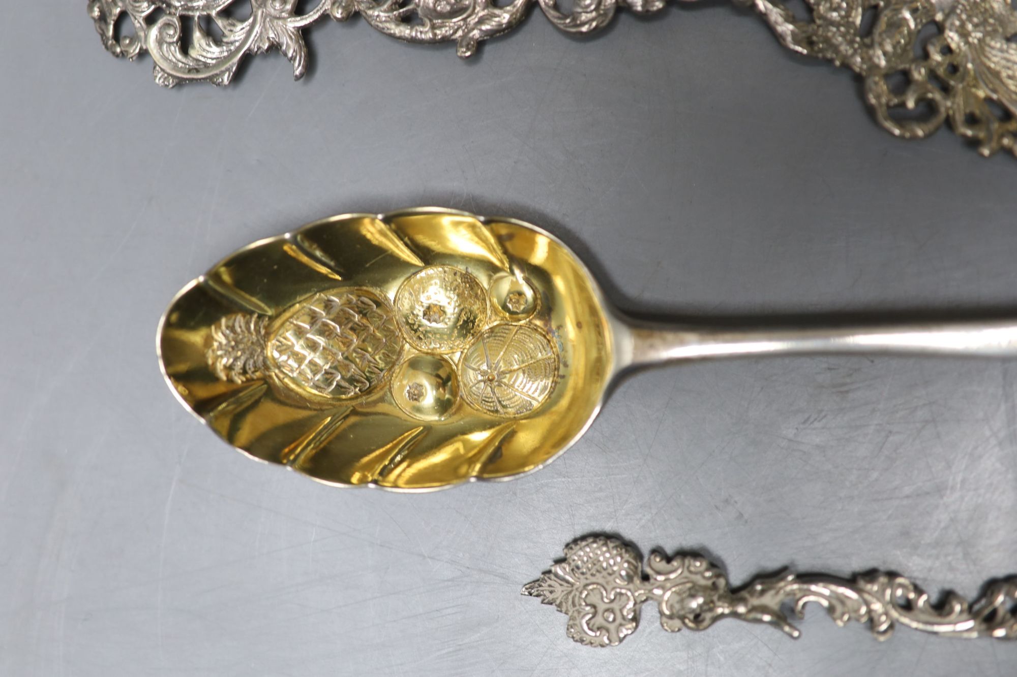 Three white metal decorative spoons and a single berry spoon